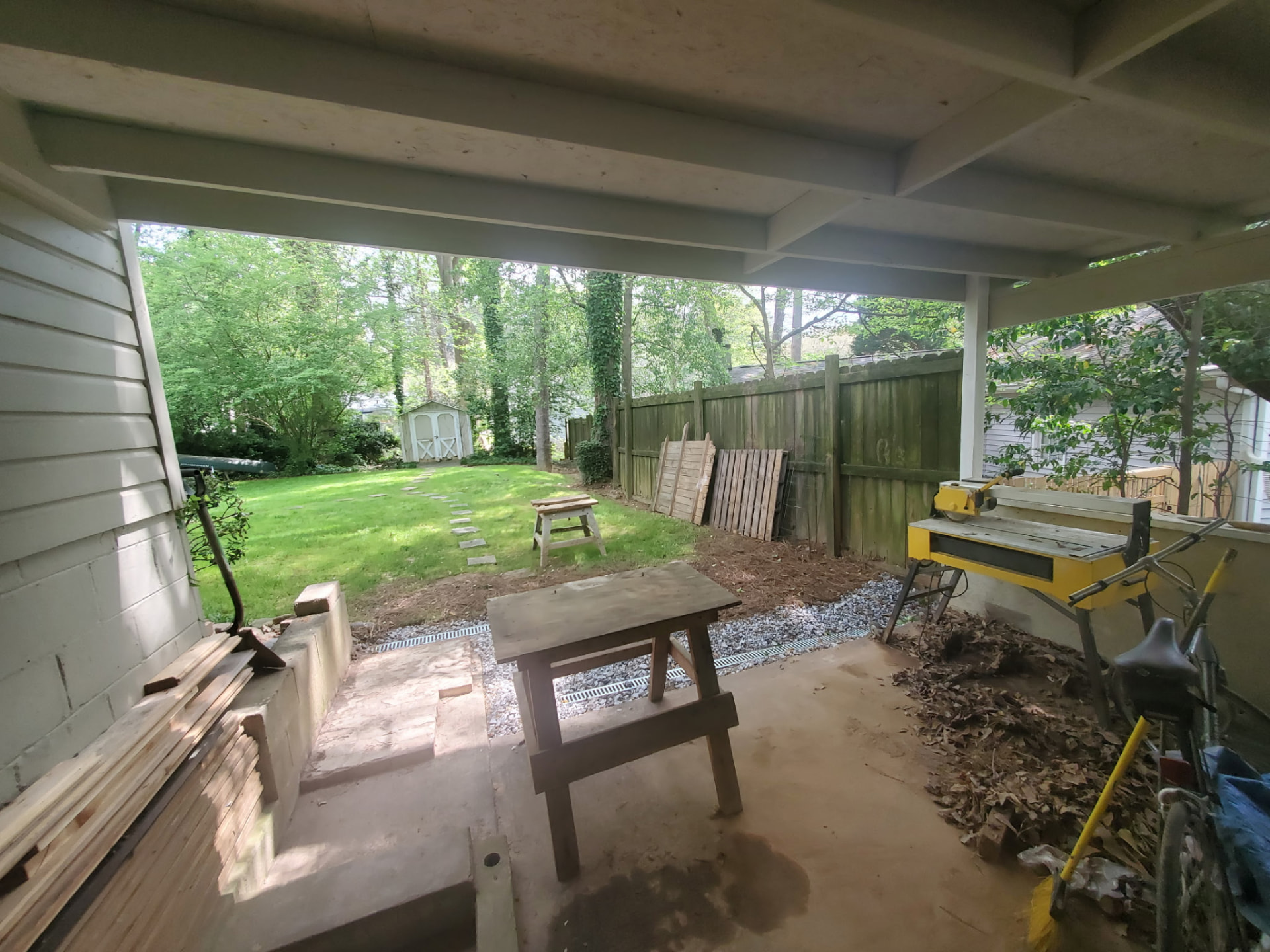 Open, unfinished area under a house used for tool storage before the shed build