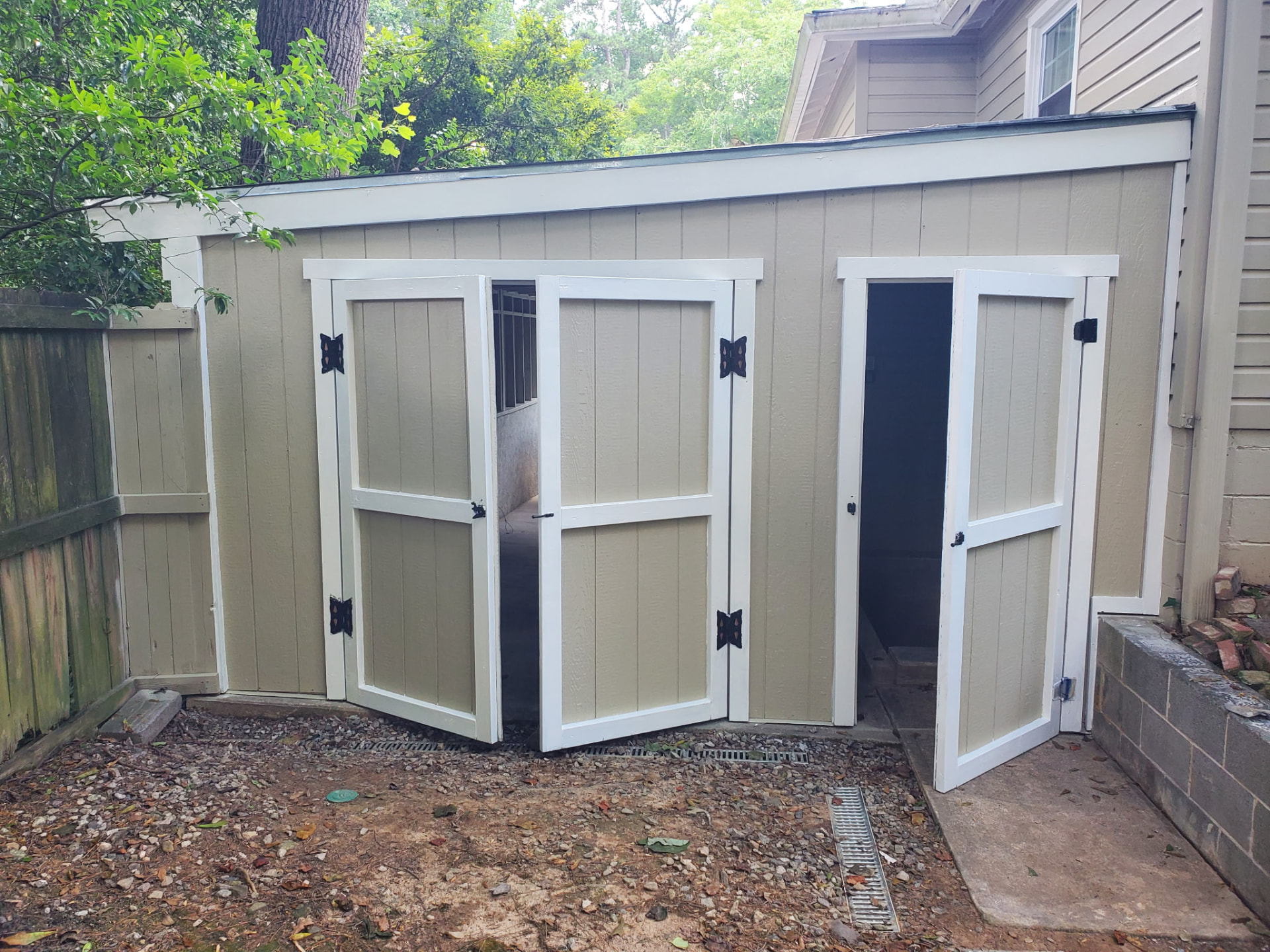 Finished enclosed storage shed with custom painted doors and white trim
