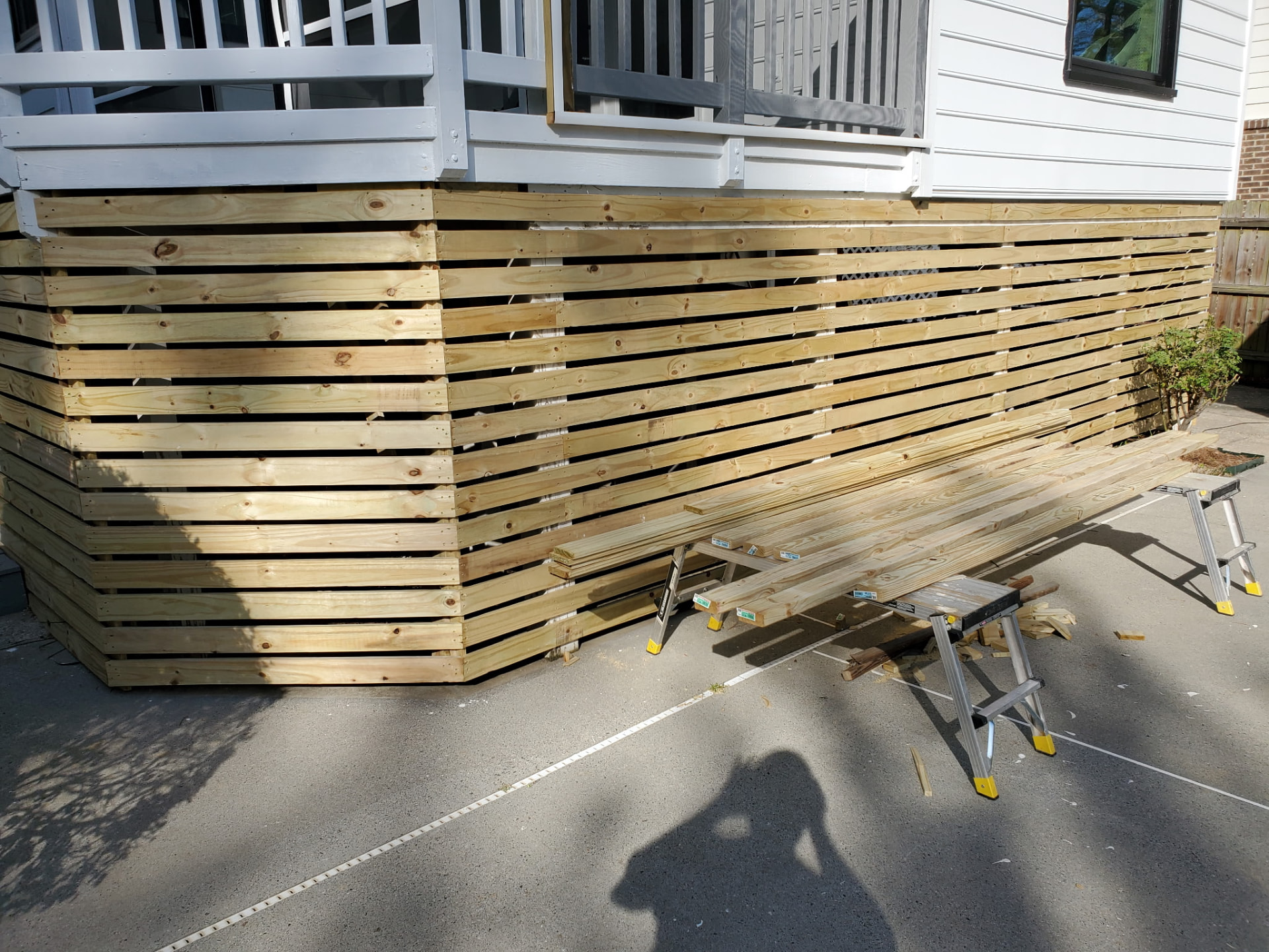 Horizontal wood slat skirting enclosing the base of an elevated deck